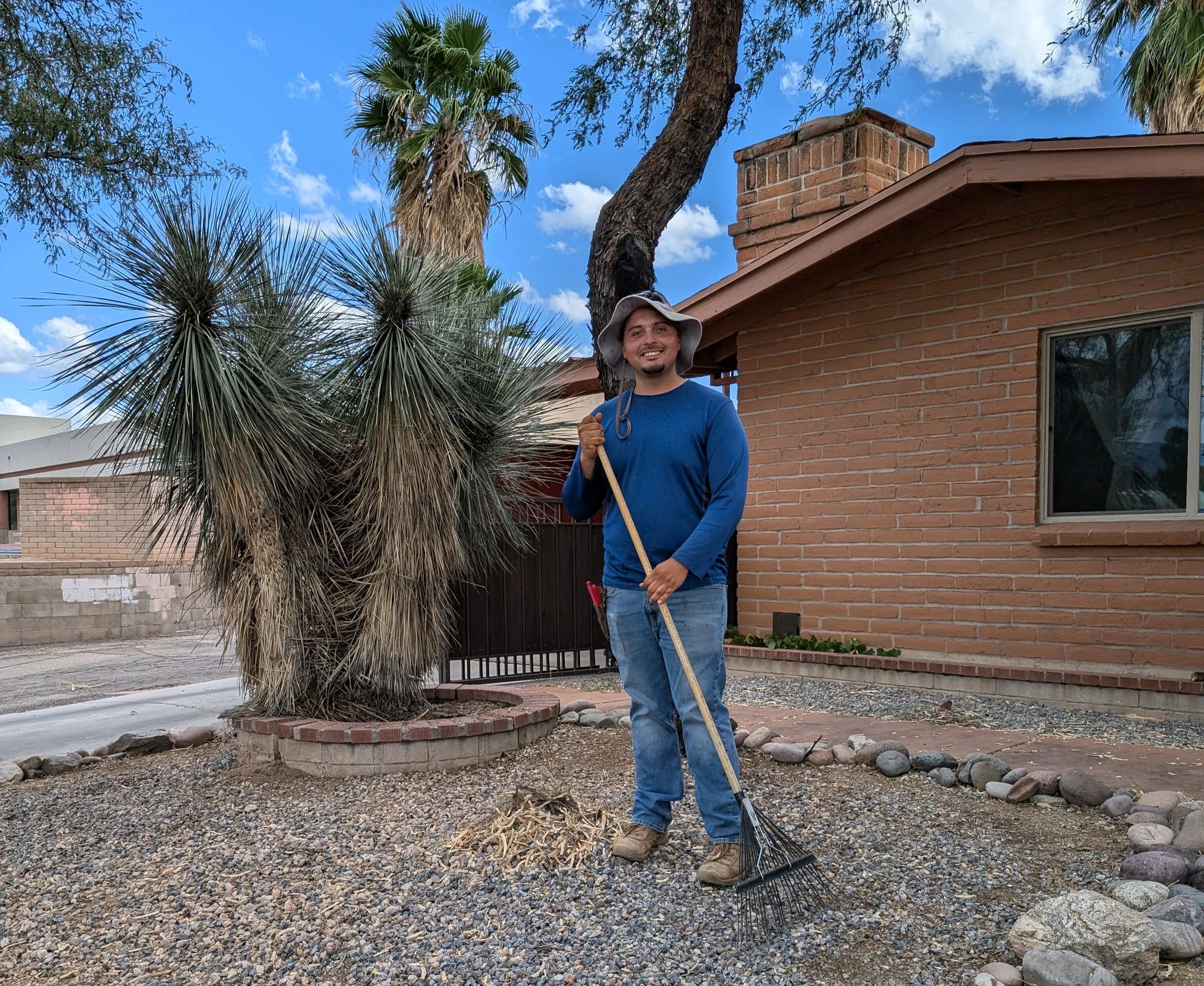Worker raking driveway